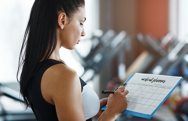 personal-trainer-with-clipboard-making-workout